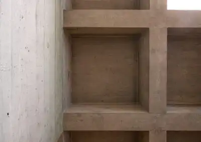 Holzregal mit Betonwand, modern und minimalistisch gestaltet. Geometrische Linien betonen das schlichte Design.