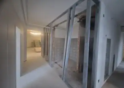 Renovierungsarbeiten in einem Innenraum mit Stahlrahmen und unvollständigen Wänden, Baustelle im Bauprozess.