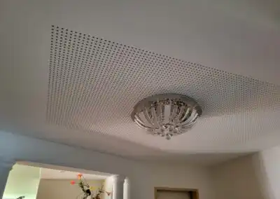 Deckenleuchte und Lochdecke im modernen Wohnzimmer-Design.