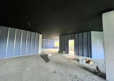 Rohbau mit Trockenbauwänden und Baumaterialien, vorbereitet für den Innenausbau eines Gebäudes.