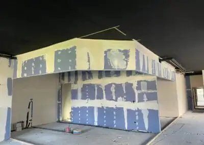 Unvollständiger Innenausbau mit Trockenbauwänden und abgehängter Decke in modernem Gebäude.