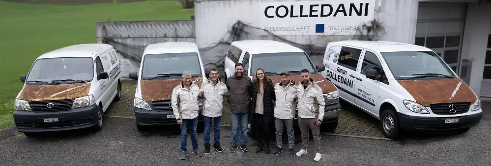 Gruppe von Mitarbeitern steht vor Firmenfahrzeugen bei Colledani Gipserei, Firmenschild im Hintergrund.